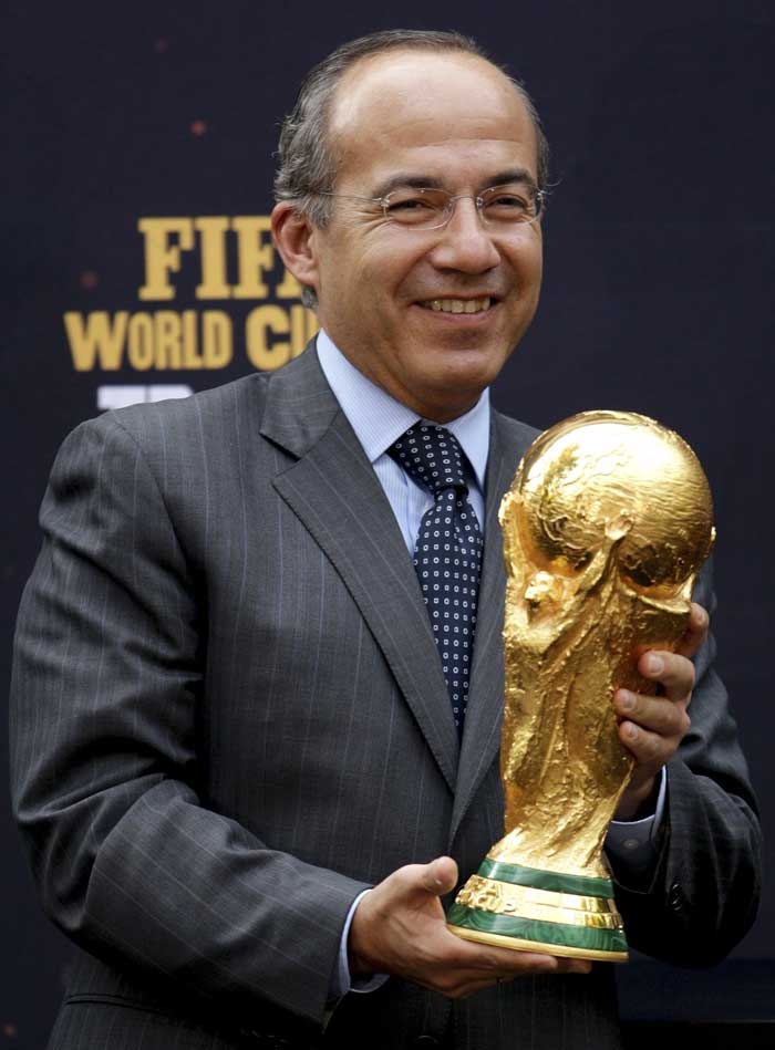 الرئيس المكسيكي فيليبي كالديرون يحمل كأس العالم خلال حفل أقيم في مكسيكو سيتي حيث سيتم عرض الكأس.