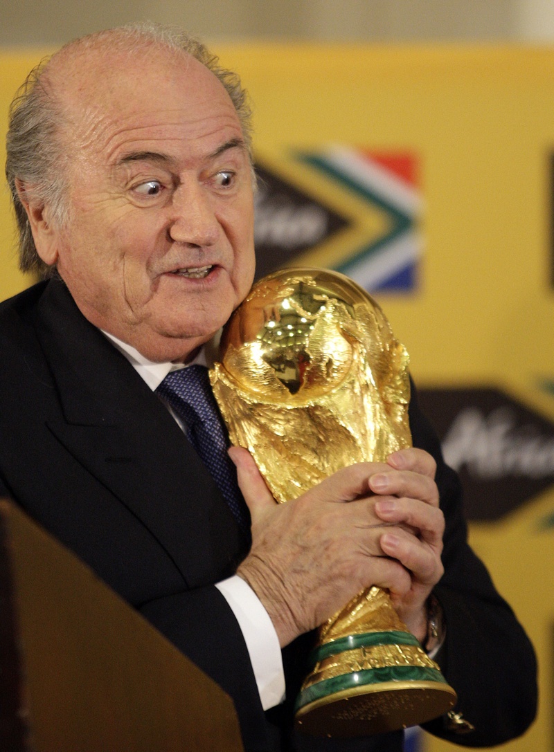 جوزيف بلاتر يحمل كأس العالم خلال مؤتمر صحفي لوسائل الإعلام الدولية بخصوص كأس العالم