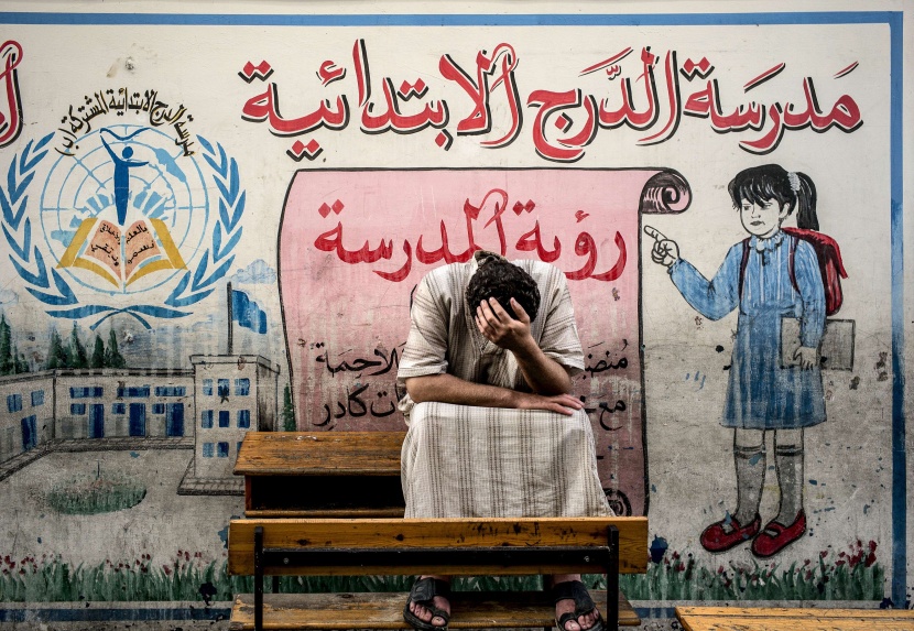 نازح فلسطيني يبكي بعد فقدانه عائلته في مدرسة تابعة للأمم المتحدة حيث اضطر الآلاف للهروب من القتال العنيف في غزة .