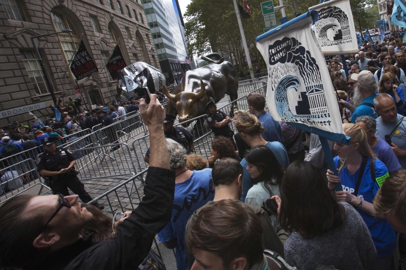 قصة مصورة : مسيرة للمحتجين على التغير المناخي في وول ستريت