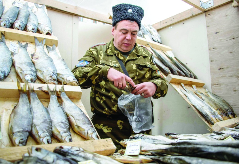 بائع داخل جناح للأسماك المجففة والمدخنة بمعرض الطعام السنوي في موسكو