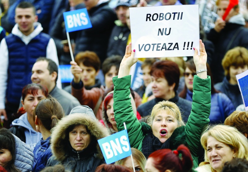 رومانية من مصنع سيارة داسيا-رينو ترفع لافتة خلال إحتجاج في مدينة مياوفيني