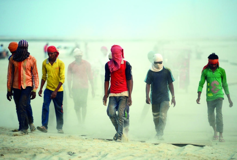 عمال هنود يعملون على إنشاء طريق جانبي في ولاية أوتار براديش الواقعة شمال البلاد.