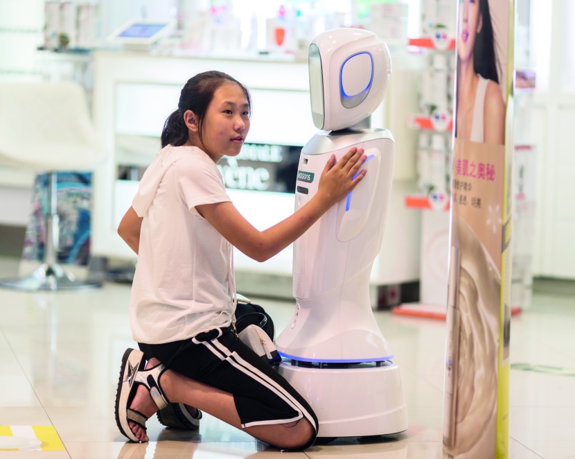 فتاة تتواصل مع روبوت بائع في أحد متاجر الصين بعد أن استحوذت على كثير من الوظائف