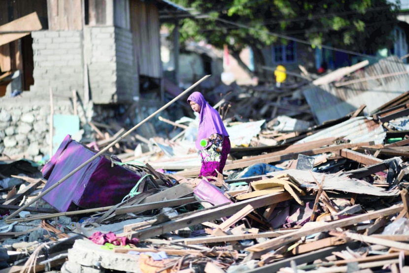 امرأة تبحث بين أنقاض منزلها عن أغراض تستطيع استخدامها