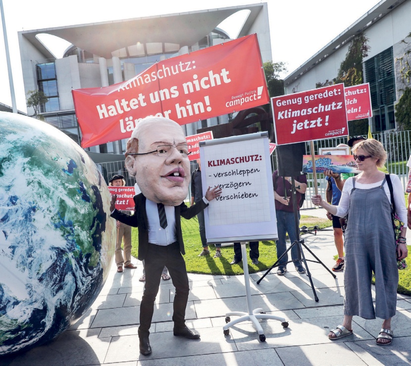 متظاهرون يحملون قناعا لوزير الاقتصاد الألماني مطالبين بحماية المناخ وفرض ضرائب على المصانع لخفض انبعاثات الكربون في ألمانيا