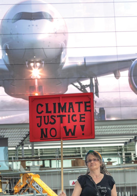 سيدة تحتج على استخدام الطائرات في مظاهرة تدعو إلى حماية المناخ