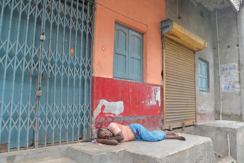 أحد العاملين مستغرق في النوم أمام عدد من المتاجر التي أغلقت أبوابها في إطار إضراب في مدينة سيليجوري الهندية