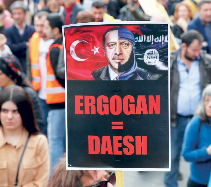 متظاهرون يرفعون لافتة كتبوا عليها «أردوغان = داعش» خلال تظاهرة خرجت في باريس