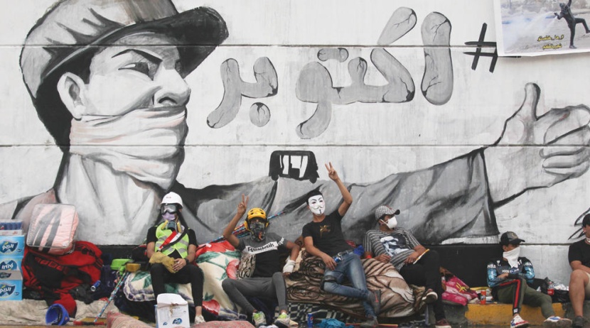 متظاهرون عراقيون يستريحون في ميدان التحرير في العاصمة بغداد خلال المظاهرات التي انطلقت في أكتوبر