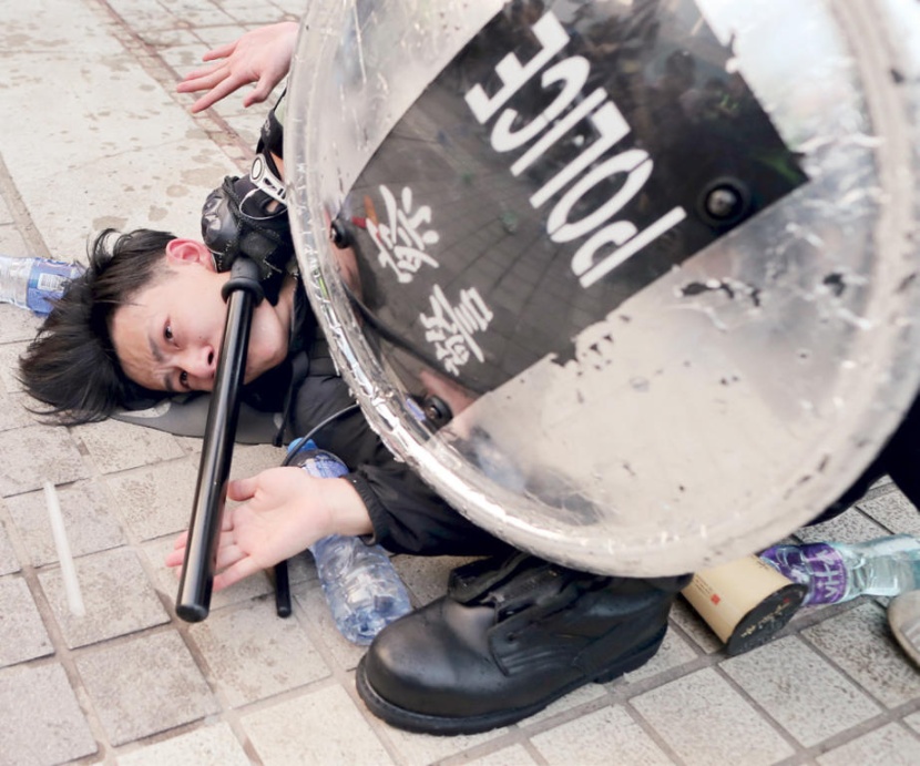 شرطي يعتقل محتجا عقب إنزال علم صيني من ساريته خلال تظاهرة في هونج كونج