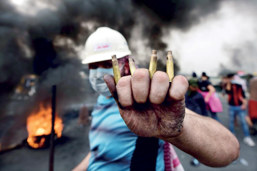 عراقي يظهر خراطيش الرصاص المستخدمة من قبل قوات الأمن لتفريق المظاهرات