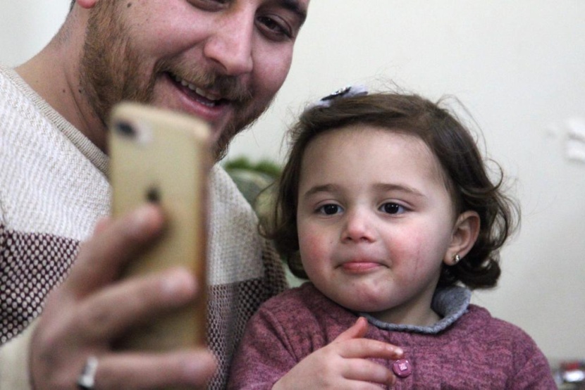 ضحكات سلوى تصدح مع كل غارة.. هكذا يحمي أب ابنته في إدلب