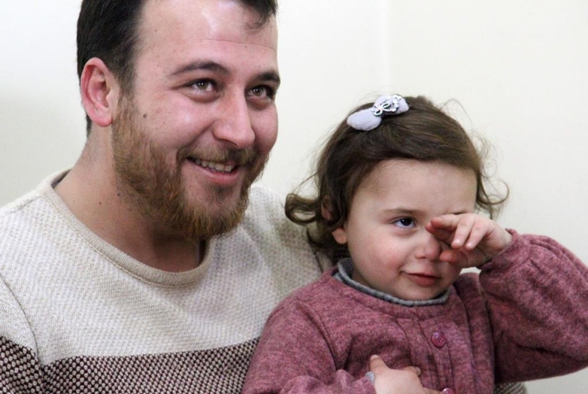 ضحكات سلوى تصدح مع كل غارة.. هكذا يحمي أب ابنته في إدلب