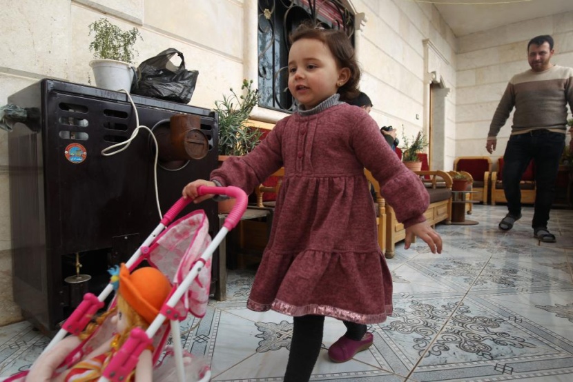 ضحكات سلوى تصدح مع كل غارة.. هكذا يحمي أب ابنته في إدلب