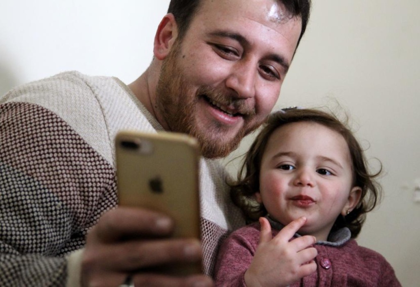 ضحكات سلوى تصدح مع كل غارة.. هكذا يحمي أب ابنته في إدلب