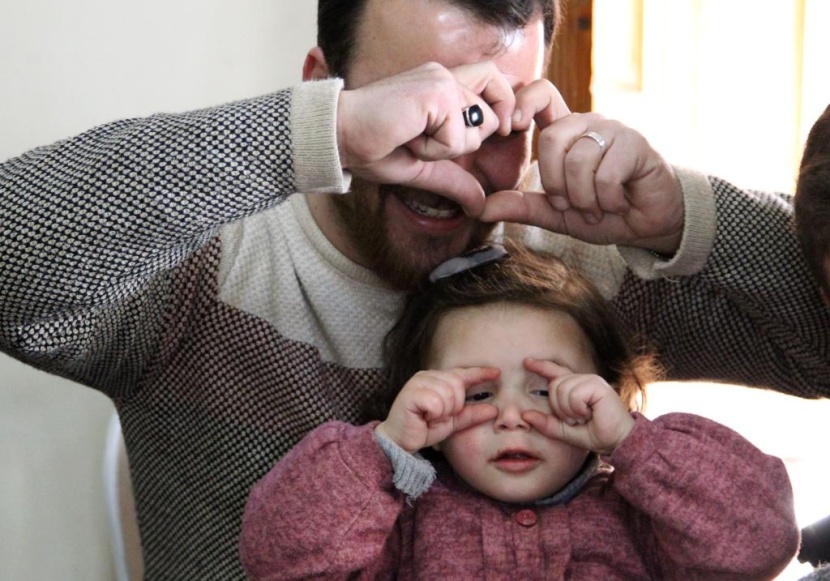 ضحكات سلوى تصدح مع كل غارة.. هكذا يحمي أب ابنته في إدلب