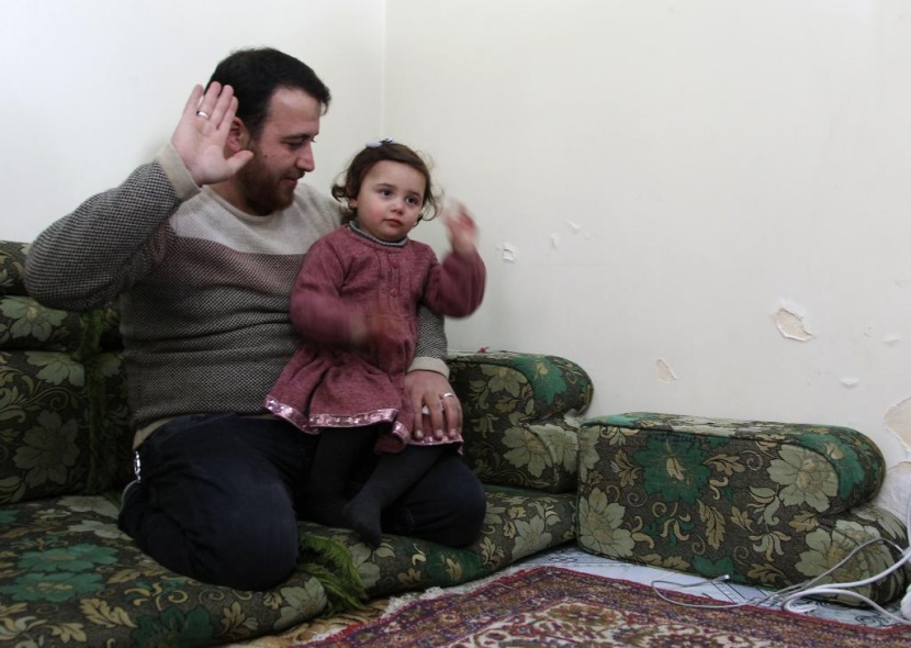 ضحكات سلوى تصدح مع كل غارة.. هكذا يحمي أب ابنته في إدلب