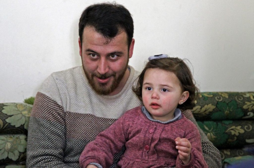 ضحكات سلوى تصدح مع كل غارة.. هكذا يحمي أب ابنته في إدلب