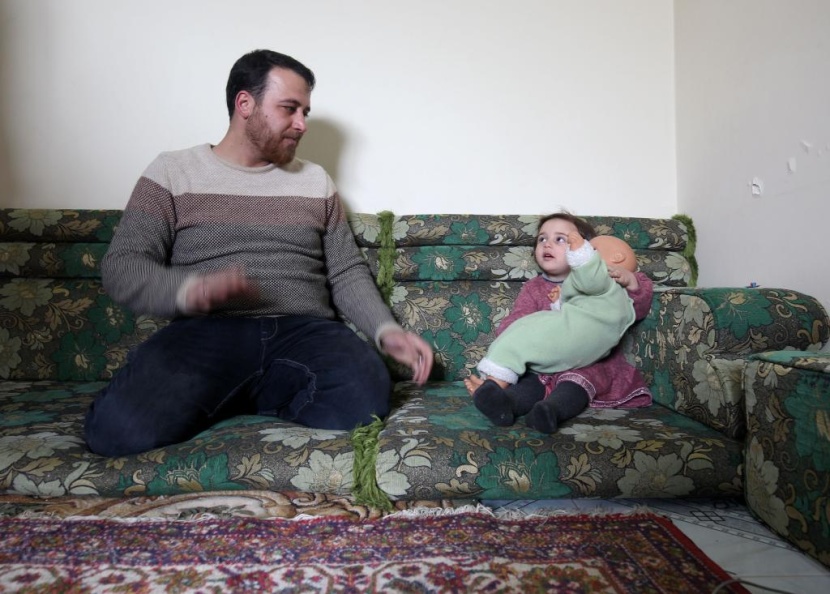 ضحكات سلوى تصدح مع كل غارة.. هكذا يحمي أب ابنته في إدلب