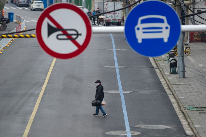 رجل يسير في شارع فارغ بمدينة ووهان التي تخلو من المارة خوفا من "كورونا"