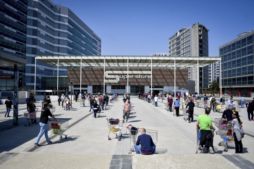 طوابير طويلة بانتظار السماح لها بالدخول للمحال التجارية في إيطاليا.  