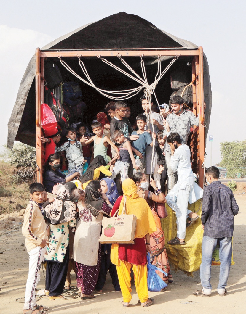 نساء وأطفال يتكدسون داخل شاحنة على مشارف مدينة مومباي للسفر إلى قراهم بعد رفع الإغلاق الجزئي
