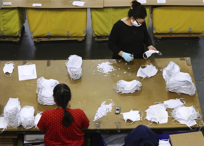  نساء يعملن في ورش مؤقتة لإنتاج أقنعة للوجه في جورجيا .