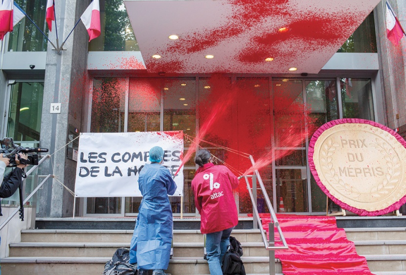 متظاهران يرشان مبنى وزارة الصحة الفرنسية بطلاء أحمر في إشارة رمزية لدماء الضحايا من العاملين في القطاع الصحي