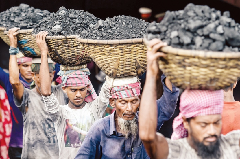عمال يفرغون الفحم من سفينة شحن في العاصمة البنجلادشية دكا
