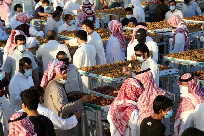 باعة تمور يعرضون منتجات مزارع القصيم في موسم عنيزة للتمور