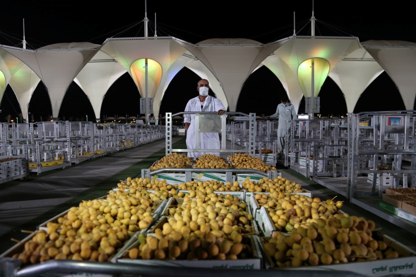 باعة تمور يعرضون منتجات مزارع القصيم في موسم عنيزة للتمور