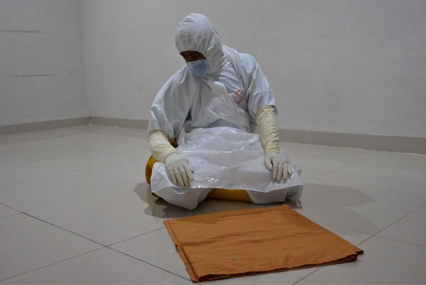 ممرض يؤدي الصلاة بعد انتهائه من رعاية مرضى فيروس كورونا في أحد مستشفيات إندونيسيا  .