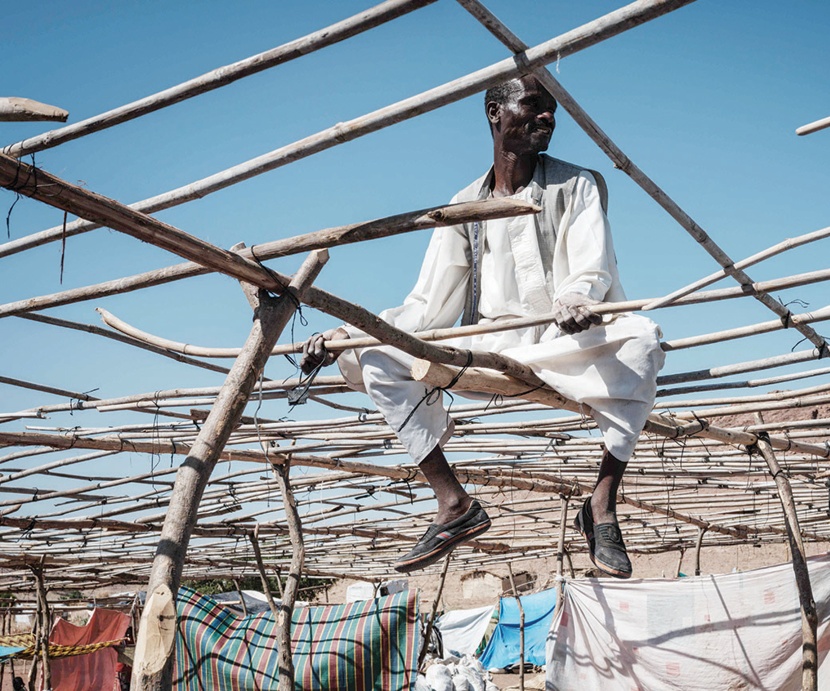 سوداني يستخدم أدوات بدائية لتجهيز مأوى للاجئين الإثيوبيين في مخيم أم ركوبة بالغضارف