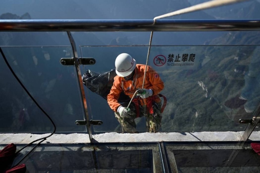 في الصين.. عمال يجمعون قمامة جبل على طريقة «سبايدرمان»