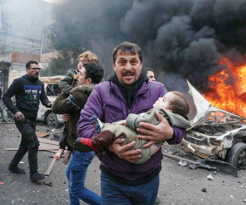 عدد من الموجودين في موقع انفجار السيارة في ريف حلب الشمالي يحملون أطفالا للنجاة بهم من النيران