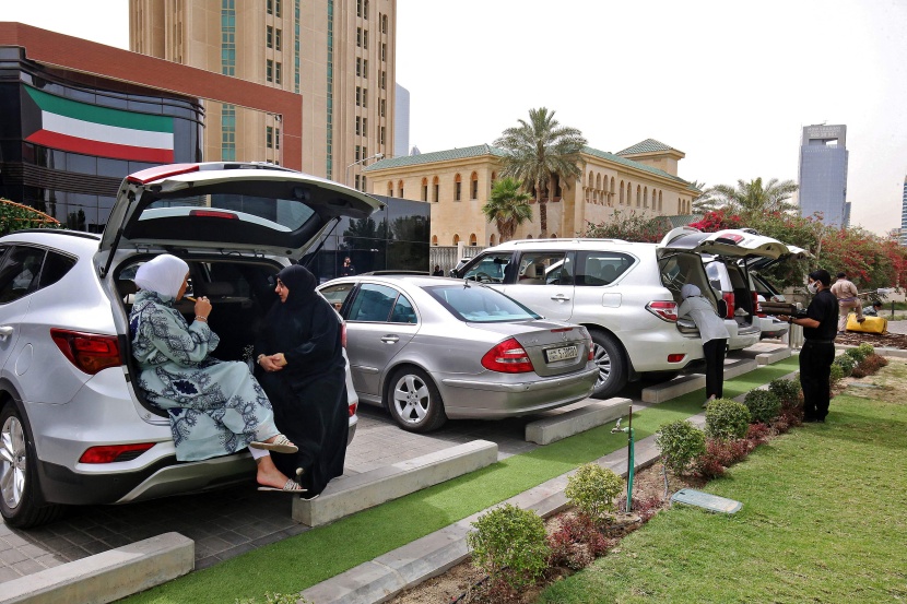 كويتيون يتناولون الطعام داخل سيارتهم بعد إغلاق المطاعم والمقاهي بسبب تفشي كورونا