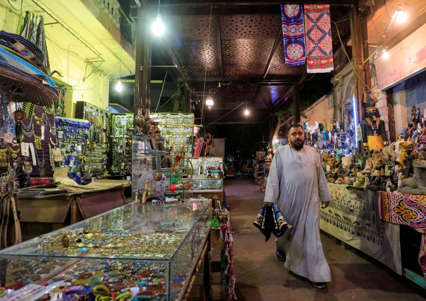  مشاة أمام متاجر الهدايا التذكارية في سوق سياحي في مدينة الأقصر المصرية