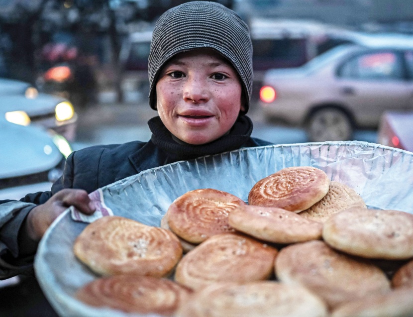 طفل أفغاني يبيع الخبز في شارع مزدحم في كابول