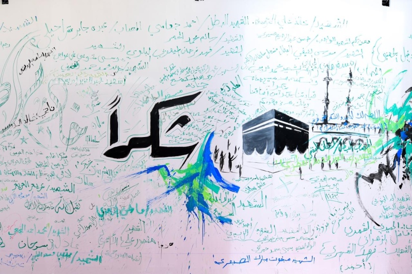 ضيوف "برنامج الملك للحج والعمرة" ينثرون مشاعرهم على أكبر جدارية في منى