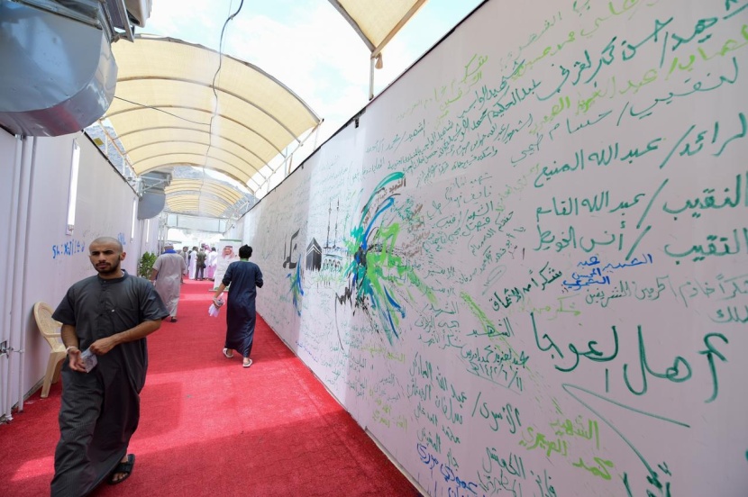 ضيوف "برنامج الملك للحج والعمرة" ينثرون مشاعرهم على أكبر جدارية في منى