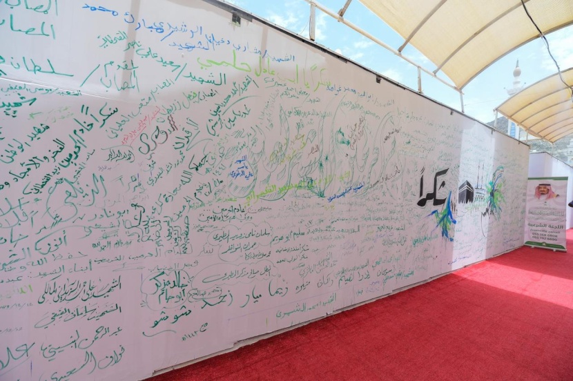 ضيوف "برنامج الملك للحج والعمرة" ينثرون مشاعرهم على أكبر جدارية في منى