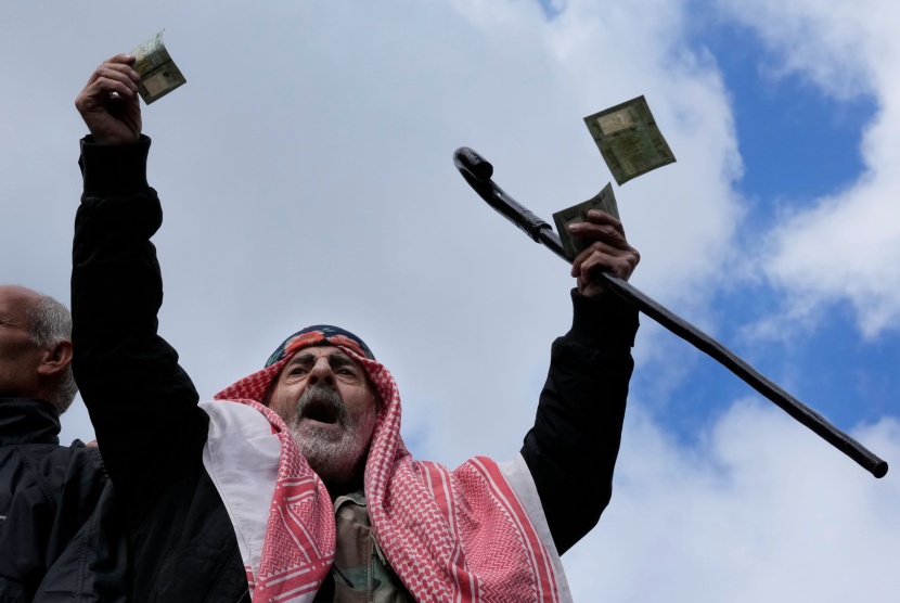 جندي متقاعد يلقي بالمال اللبناني وسط مظاهرات غاضبة