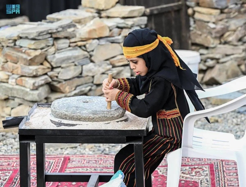 طفلة تستخدم الرحى أمام الزوار في مهرجان الأطاولة التراثي الذي يشهد الفعاليات التراثية والثقافية التي تحاكي تراث وتاريخ المنطقة الجنوبية. «واس» فتاة الرحى