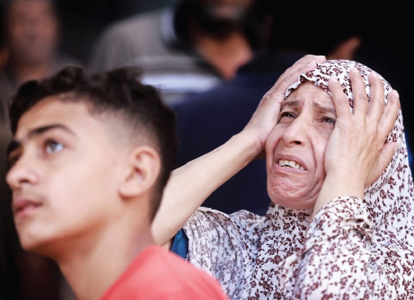فلسطينية وابنها أثناء غارة إسرائيلية على مخيم النصيرات وسط غزة